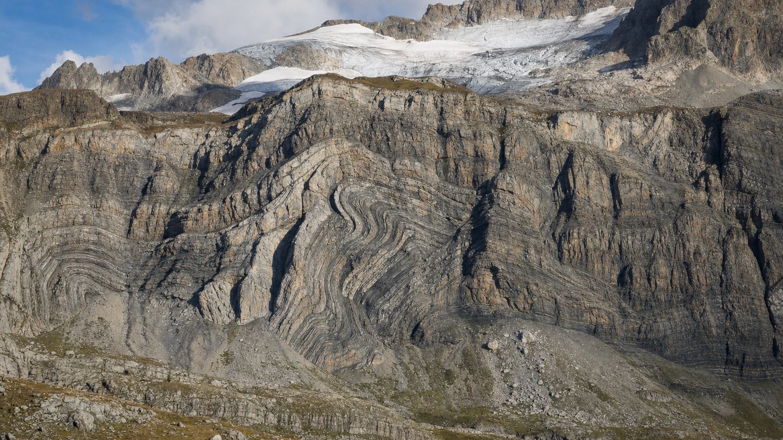 Parois calcaires étagées du cirque de Gavarnie dominant une prairie, avec la cascade qui tombe de la muraille