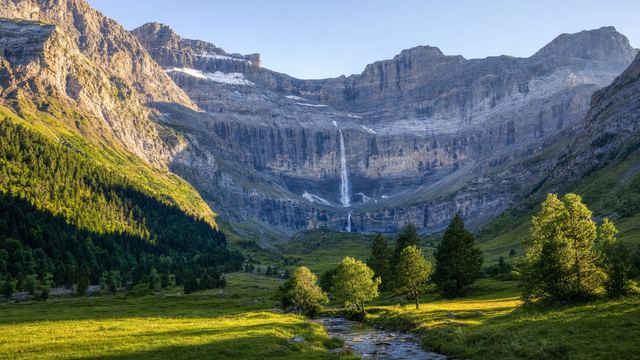 Mountain lake ringed by granite peaks in the French Pyrenees on a clear summer morning, near the Spanish border