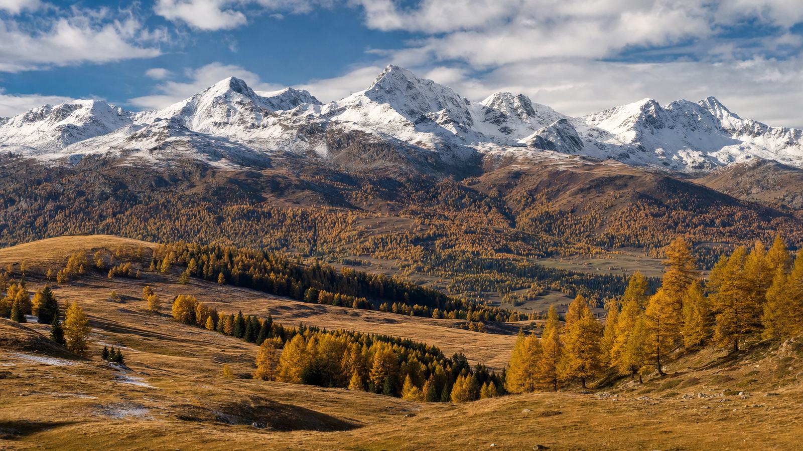 Versant pyrénéen aux couleurs d’automne, pâturages d’altitude et premiers sommets saupoudrés de neige
