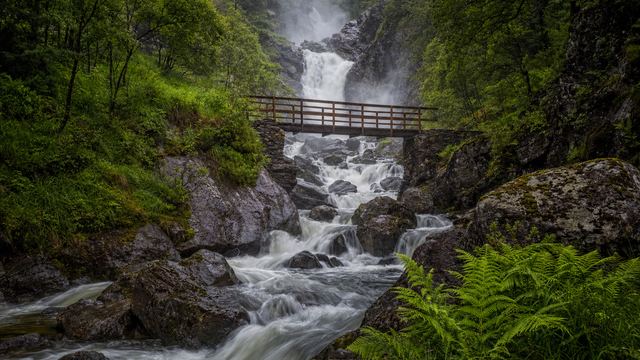 Sentier longeant un torrent et des cascades dans la vallée de Cauterets, sommets des Pyrénées en arrière-plan