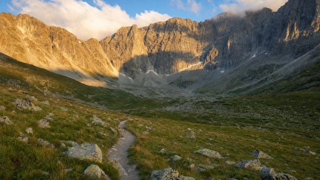 Panneau d'information à l'entrée d'un sentier de montagne, avec un cirque pyrénéen en arrière-plan